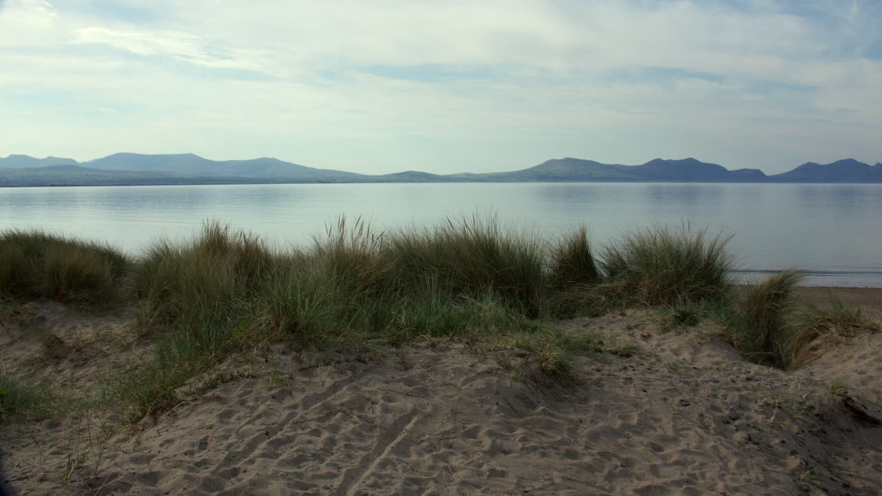 Wide shot in the dunes looking over the beach at Llanddwyn beach and at the Newborough National Nature Reserve