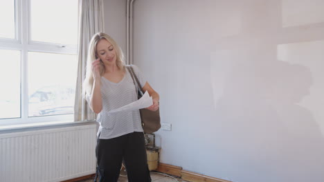 female first time buyer looking at house survey in room to be renovated