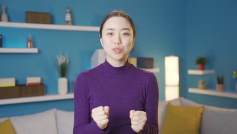 happy asian woman giving speech towards camera.