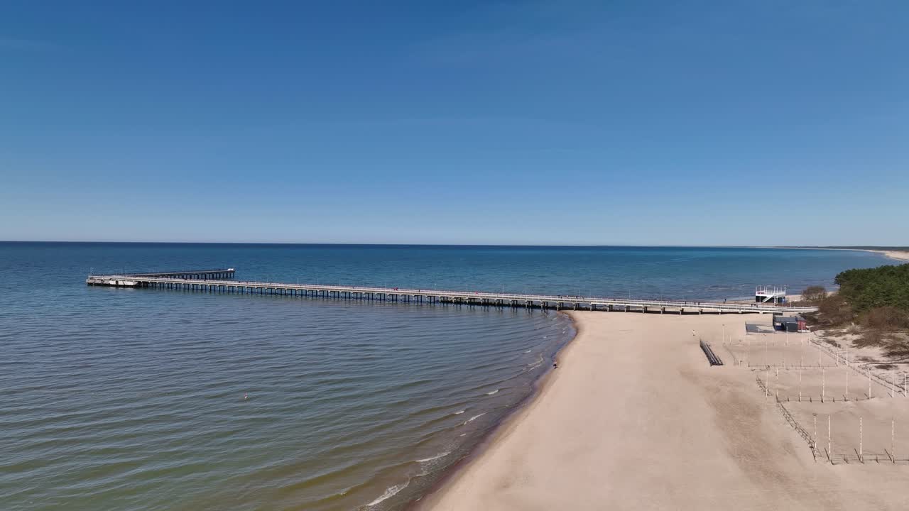 Panoramiczny widok na most stojący na plaży w Połądze, prowadzący do Morza Bałtyckiego