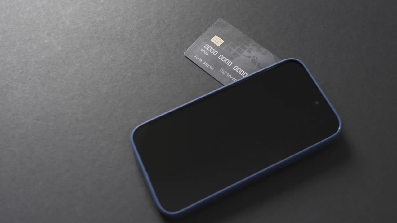Video of smartphone with blank screen, boxes and credit card with copy space on grey background