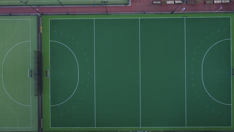 aerial view looking down at a bright green hockey field and moving to a second differently colored field