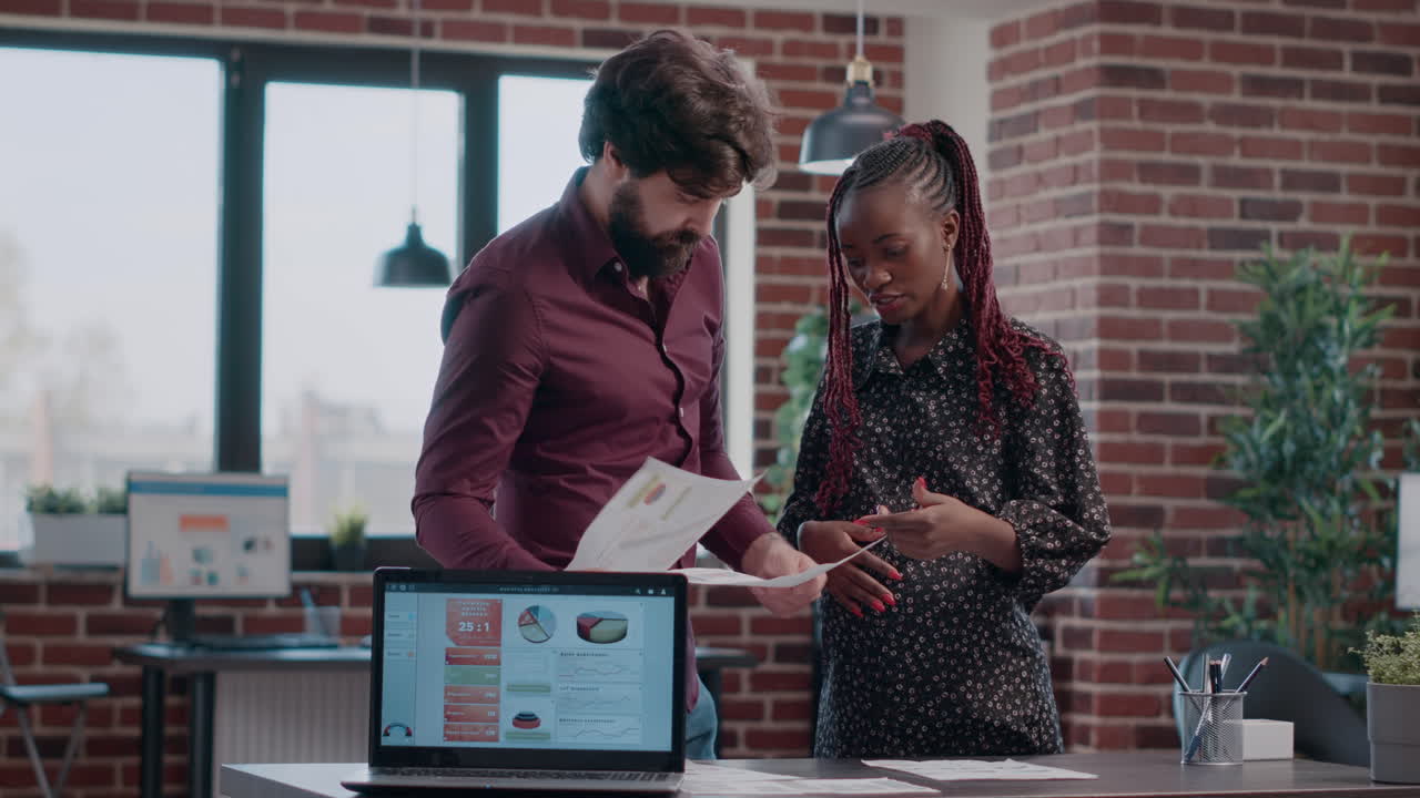 Pregnant woman and colleague brainstorming ideas for project planning