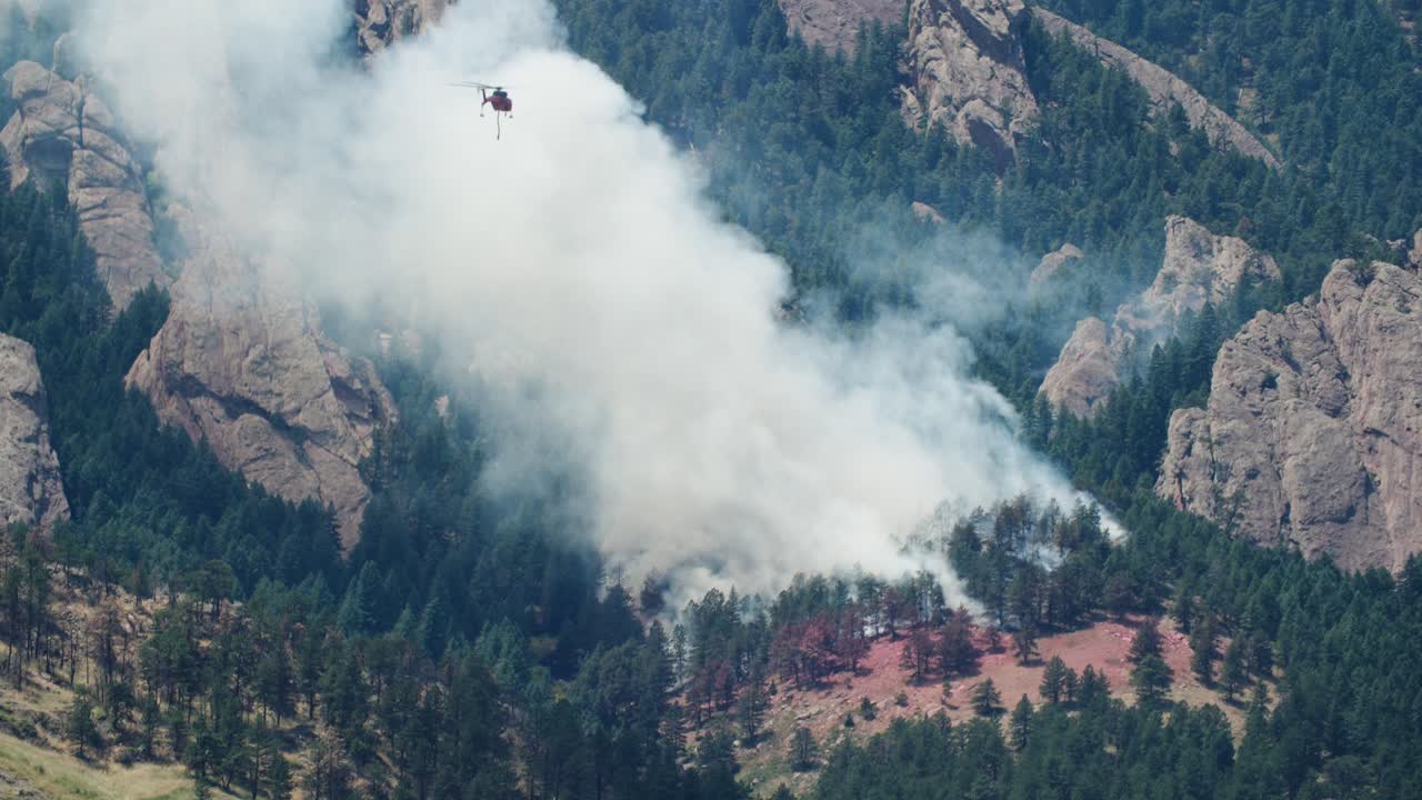 Pompieri in elicottero che scaricano acqua sull'incendio Dinosaur. Pompieri di Boulder, Colorado, impegnati in un incendio boschivo vicino a Flatirons