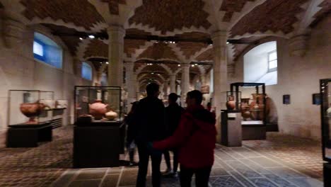 visitors walking through louvre museum's exhibit hall