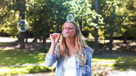 blonde woman in slow motion blowing bubbles