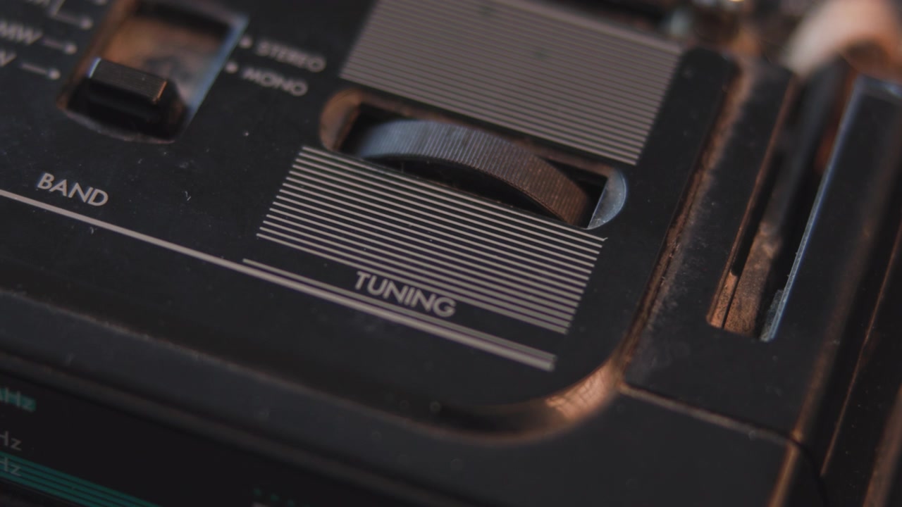 White Finger Fine Tuning Radio Dial, Closeup On Rotary Wheel And Labeled Tuning Strip, Focused Gesture