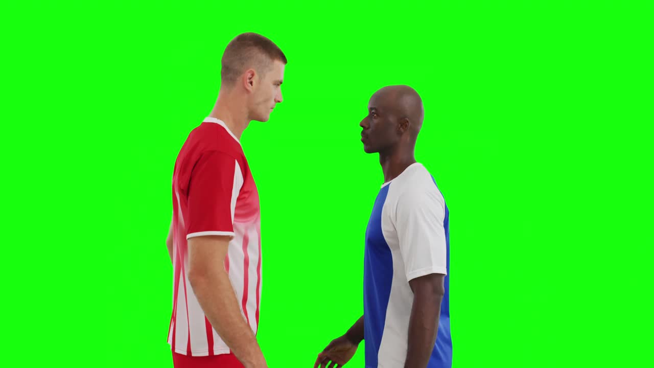Video of two diverse male soccer players facing each other on green screen background