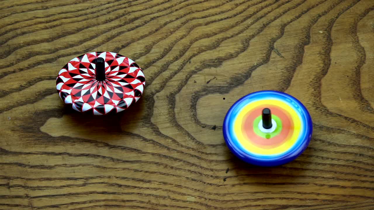 две металлические вихри игрушки на старом деревянном столе из дуба