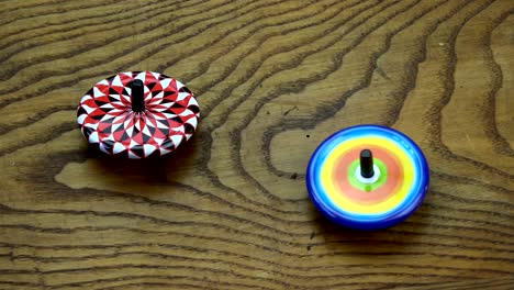 two metal whirligigs toys on old oak wood table