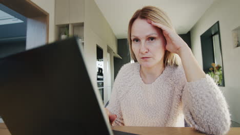 mujer triste pensativa sentada en el monitor de la computadora portátil. lente ancha 4k disparado