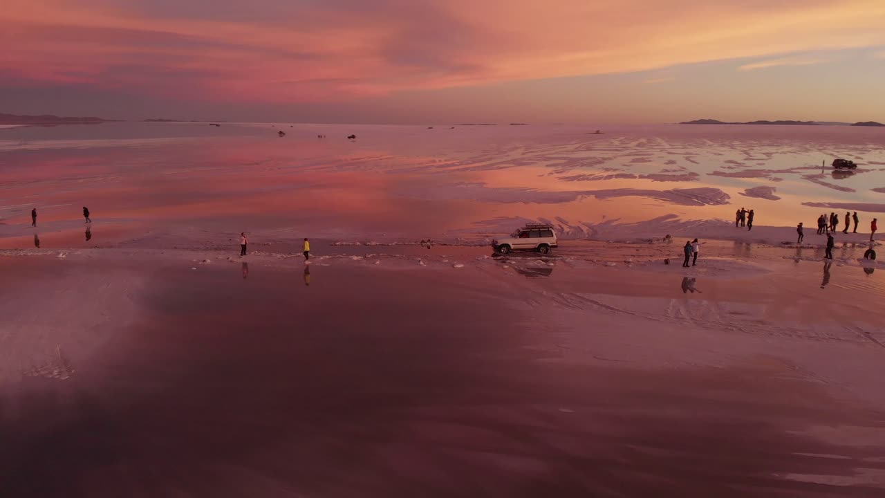 일몰 동안 살라르 데 우유니에서 지프의 회전 샷