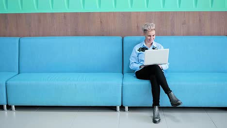 woman working on laptop in modern waiting area