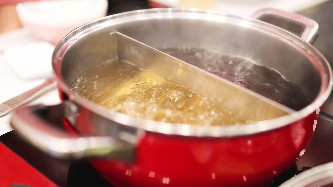 Zuppa in ebollizione in un hotpot diviso