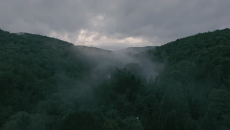 Drone-Volando-A-Través-De-Un-Hermoso-Paisaje-Neblinoso-En-La-Cima-De-La-Montaña,-Valle-Con-Puesta-De-Sol