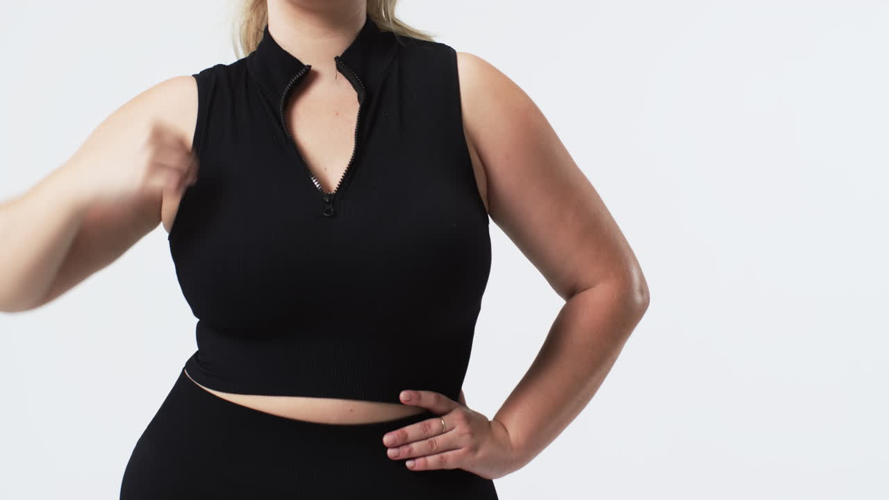 Caucasian beautiful plus size woman posing confidently in black sleeveless top and matching pants