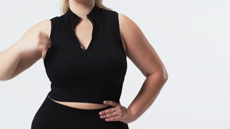caucasian beautiful plus size woman posing confidently in black sleeveless top and matching pants