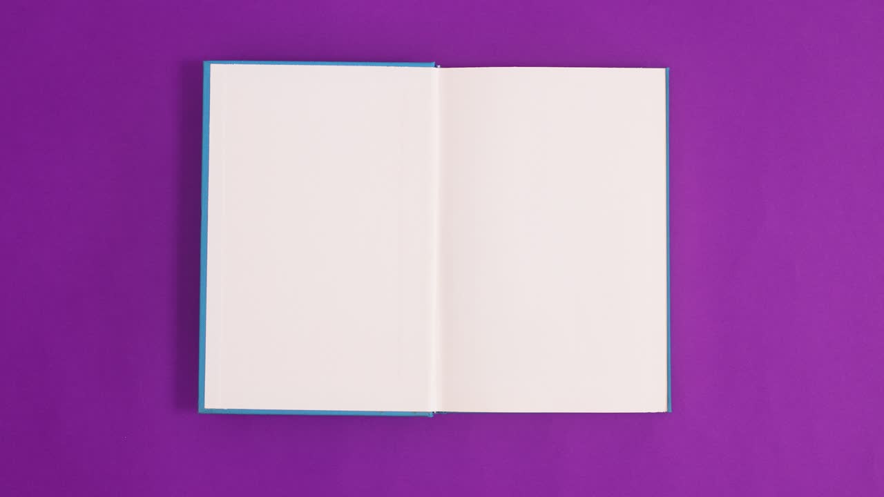 Blue vintage hardcover book appear and open with copy space on purple background. Stop motion flat lay