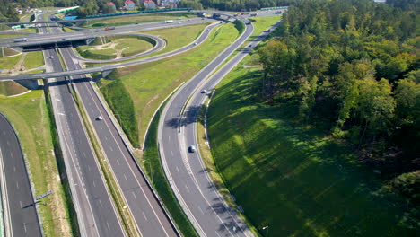 Drone-dolly-tilt-up-flies-along-highway-offramp-to-Gdynia-Wielki-Kack,-Poland