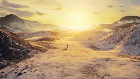 3D-animation-of-a-person-walking-through-the-rugged-snowy-landscape-while-the-sky-is-colored-by-the-setting-sun