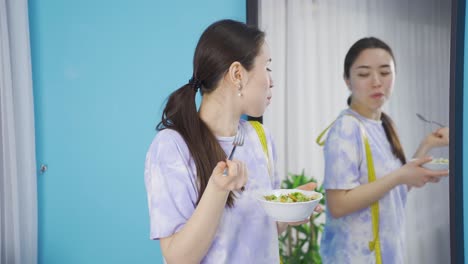 행복한 아시아 젊은 여성이 건강한 식단을 먹고 있습니다.