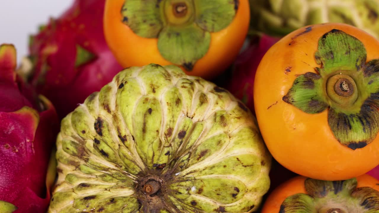 exhibición vibrante de la fruta del dragón, la cherimoya, el caqui