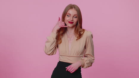 Cheerful-girl-in-beige-blouse-looking-at-camera-doing-phone-gesture-like-says-hey-you-call-me-back