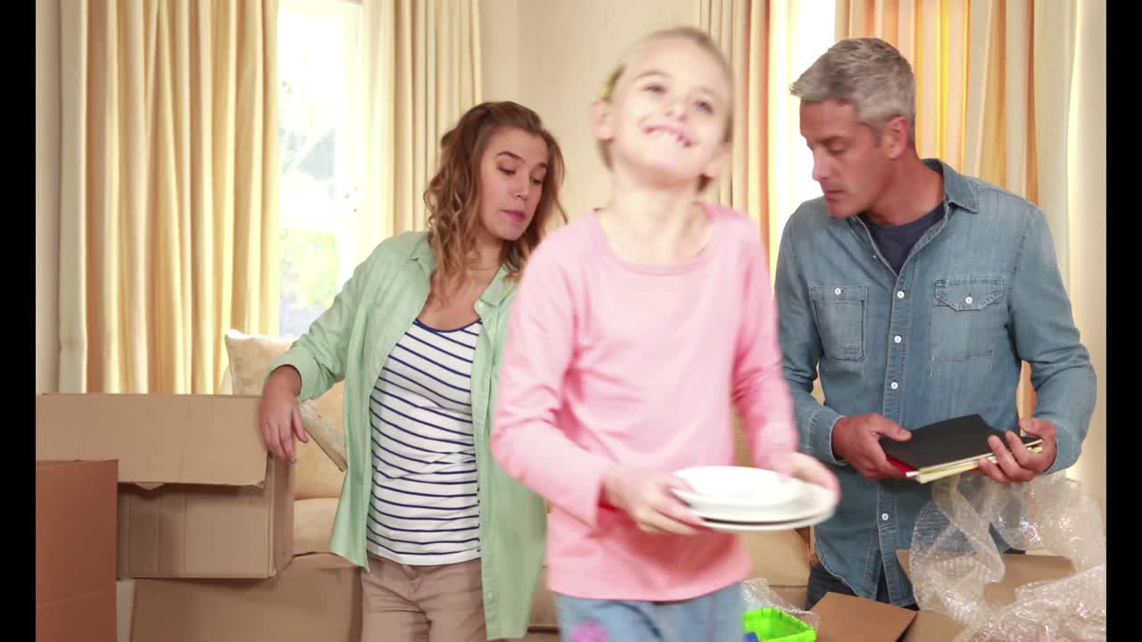 가족 들 이 움직이는 상자 들 을 풀고 있다