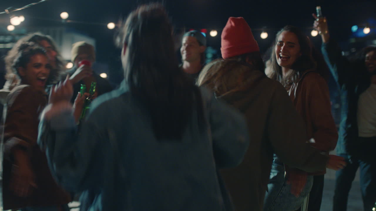 grupo feliz de amigos bailando a la música animada de la fiesta en la azotea disfrutando de la celebración del fin de semana en la ciudad urbana por la noche