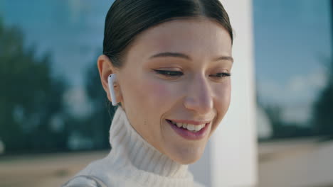 girl answering call headphones on city street closeup. woman talking headset.