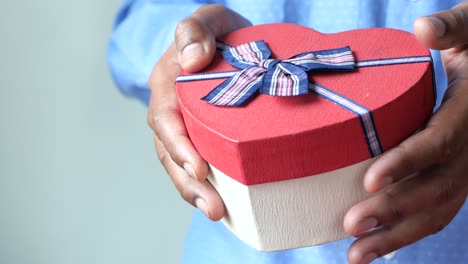 person holding a heart-shaped gift box