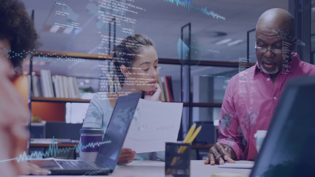 Coworkers discussing report in business meeting, with animated infographics appearing above laptops