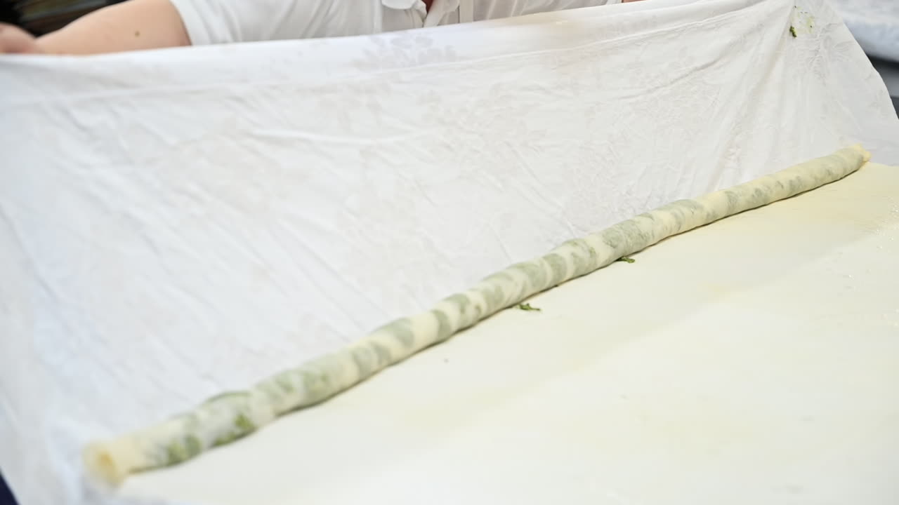 Cook rolling dough with filling for placints, Romanian and Moldovan traditional food. Slow motion