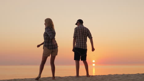 a woman and her teenage son dance together a funny dance on the beach learn fashionable dance moveme