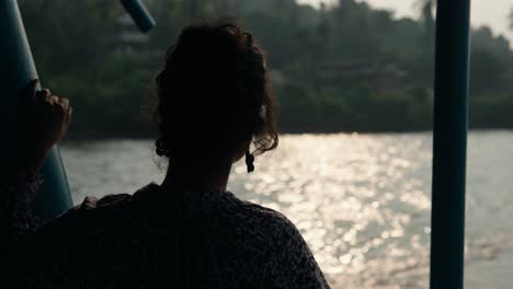 Graceful-slow-motion-shot-of-the-silhouette-of-a-young-woman-on-a-traditional-Indian-boat