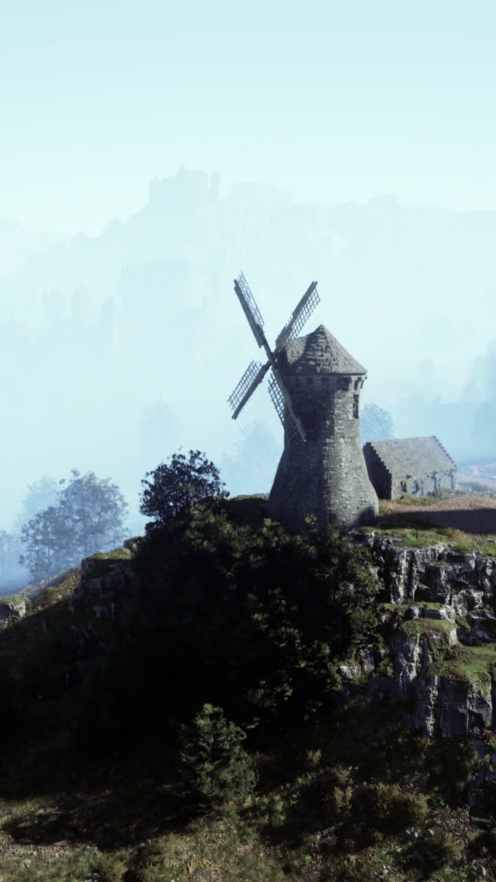 molino de viento en una colina en un paisaje brumoso