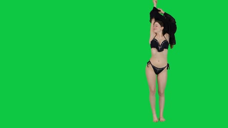 Beautiful-female-model-takes-off-her-dress-to-reveal-bikini-in-front-of-a-green-screen