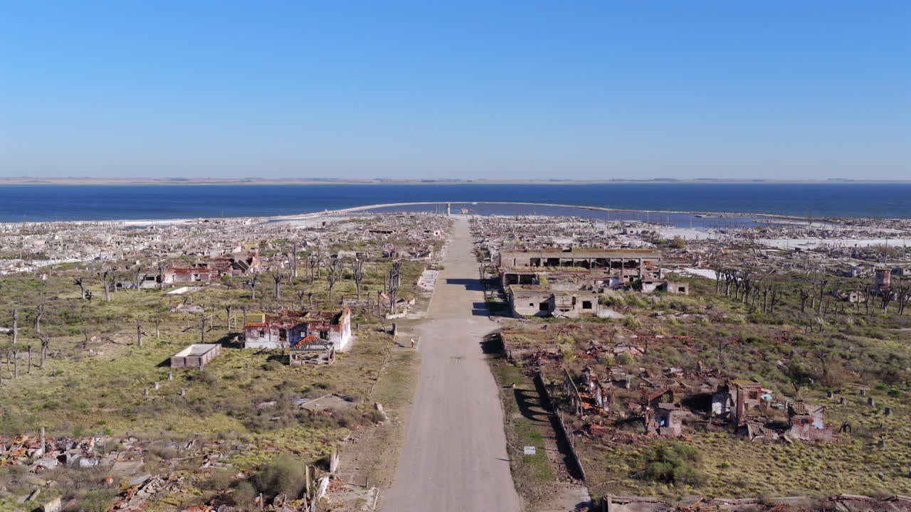Drone ascend reveals the scale of Villa Epecuén, Argentina, where a 25-year hypersaline flood has left behind a white, salt-encrusted wasteland of collapsed structures and ruins and petrified trees