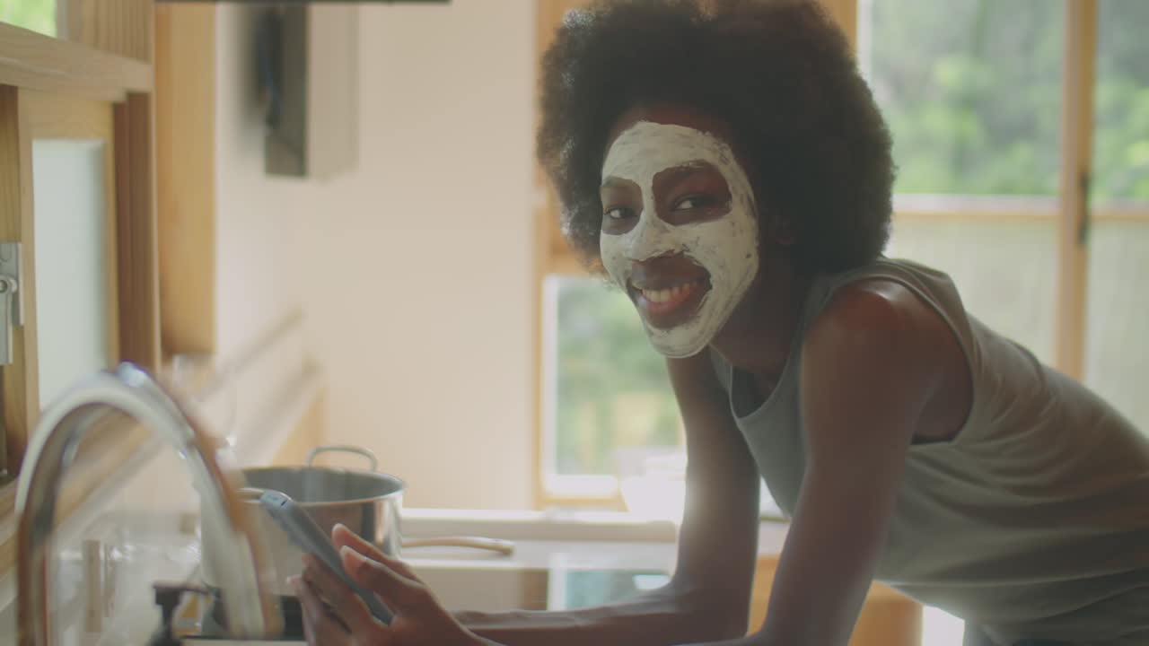 Portrait of Black Woman with Face Mask and Phone at Home