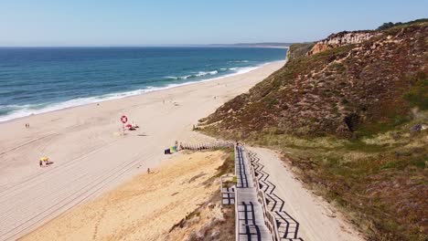 Playa-Praia-Das-Bicas-En-Castelo,-Alentejo,-Costa-Oeste-De-Portugal---Vista-Aérea-De-Drones-De-La-Larga-Escalera-A-La-Playa-De-Arena-Dorada-Y-Costa-Rocosa