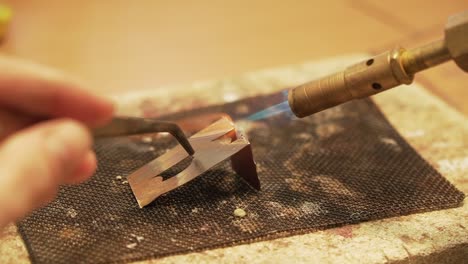 Soldering-metal-plates-with-butane-gas-flame-burner---close-up-shot