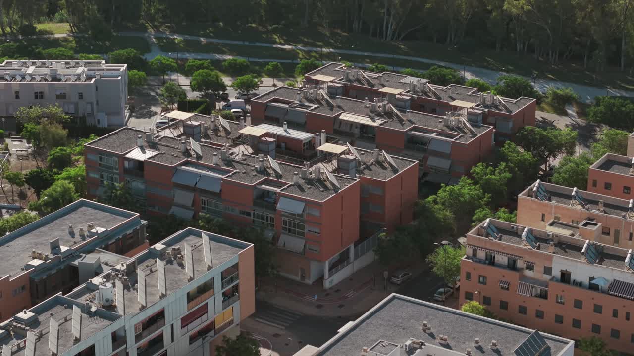 Aerial view of modern red-brick apartment buildings surrounded by greenery in Málaga, Spain