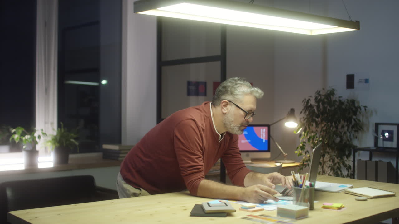 Mature Designer Working in Office at Night