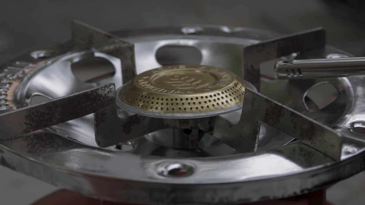 낮에는 실내에서 요리하기 위해 구리 단일 연소기 가스 스토브를 켜고 있습니다.