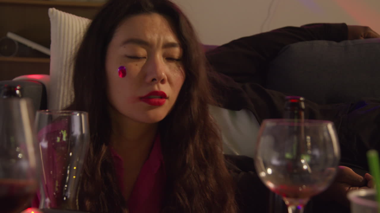 집 파티에서 알코올을 마신 후 소파에서 깨어나는 커플의 클로즈업은 숙취로 고통받고 있습니다.