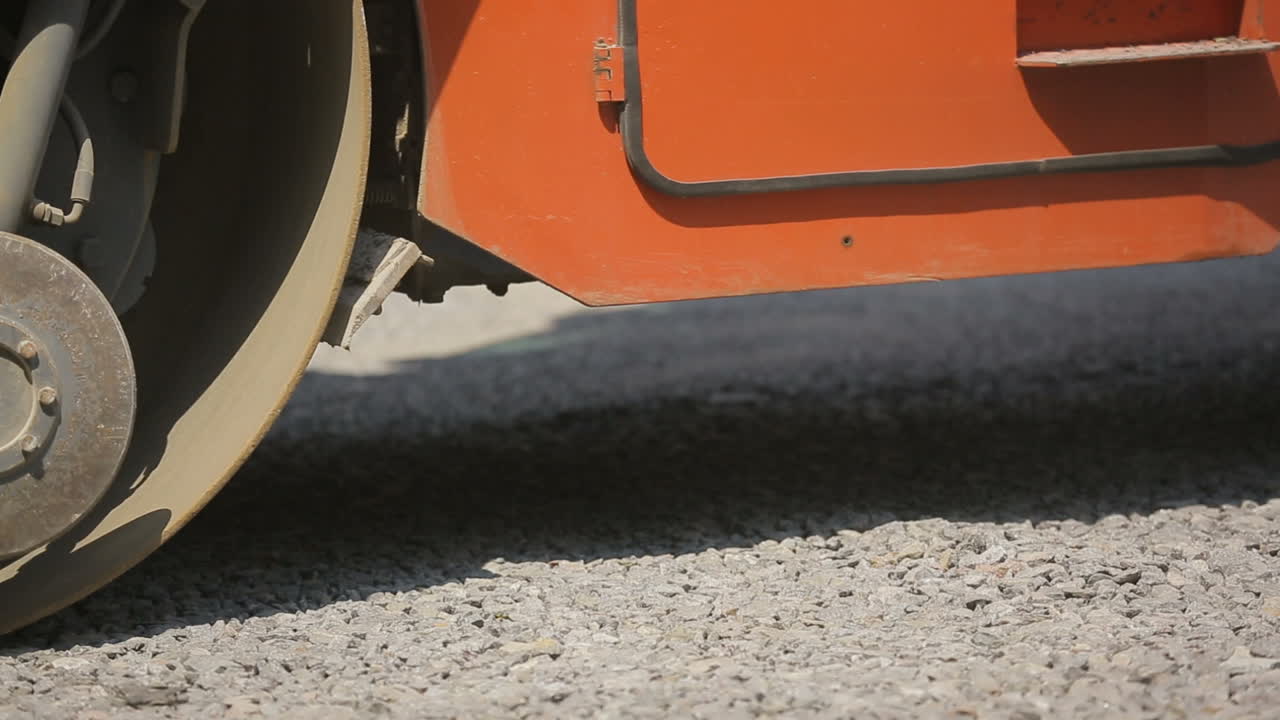Road Roller Working On A Gravel. Road roller laying gravel during road construction