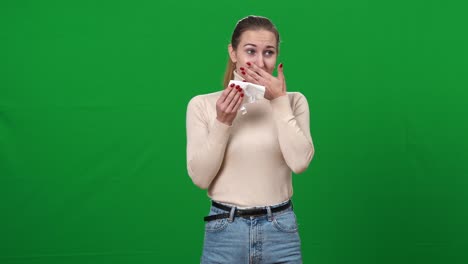 young emotional caucasian woman crying wiping tears with tissue. portrait of young lady on green screen expressing emotions. chromakey