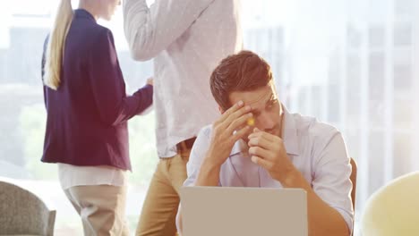 Tensed-male-business-executive-using-laptop