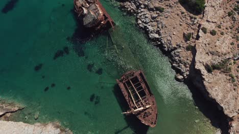 Una-Vista-Superior-Por-Drones-Del-Barco-Abandonado-En-La-Bahía-De-Liverio-Cerca-Del-Pueblo-De-Kalotaritissa,-Islas-Cícladas,-Grecia