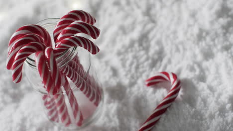 Video-Von-Weihnachtszuckerstangen-Im-Glas-Und-Kopierraum-Auf-Schneehintergrund